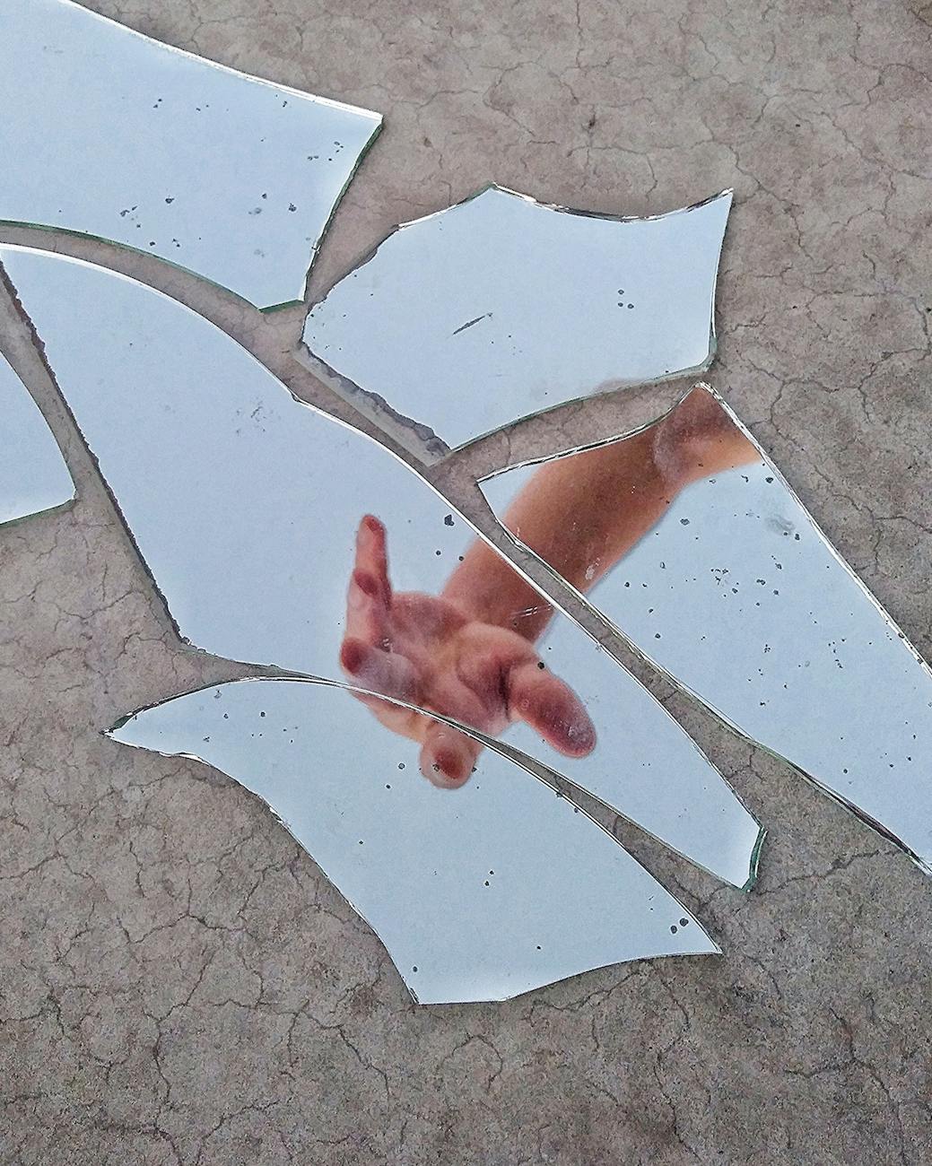 hand in broken mirror